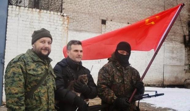 Марков під червоним прапором СРСР стоїть у центрі з кішкою на руках. Можна собі уявити, яка дичина в голові у людини, що воює за комунізм і державу, яка розпалося 27 років тому і вже ніколи не буде відновлена