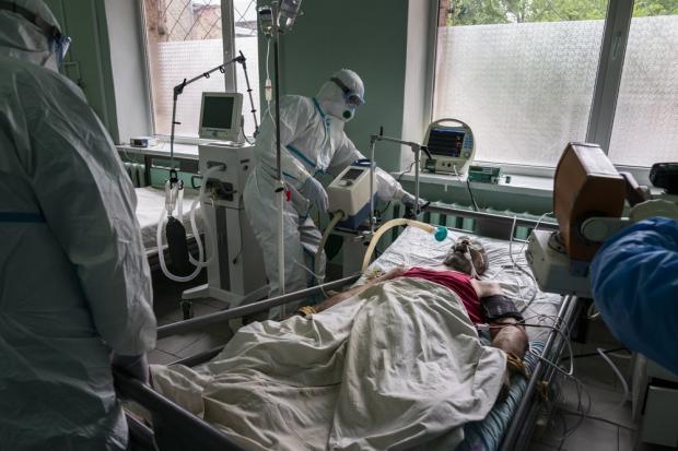 Лікарі готують пацієнта з коронавірусом до рентгену легень у відділенні інтенсивної терапії в обласній лікарні в Чернівцях