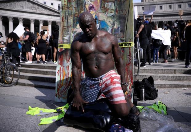 Участник протеста в Нью-Йорке, изображающий сцену гибели Джорджа Флойда
