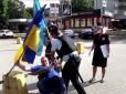 Шиють напад на поліцейського: Росіянин під час акції​ протесту, падаючи, збив кашкет силовику українським прапором (відео)