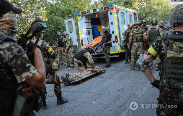 Українські бійці рятують товариша, пораненого поблизу Іловайська 10 серпня 2014 року