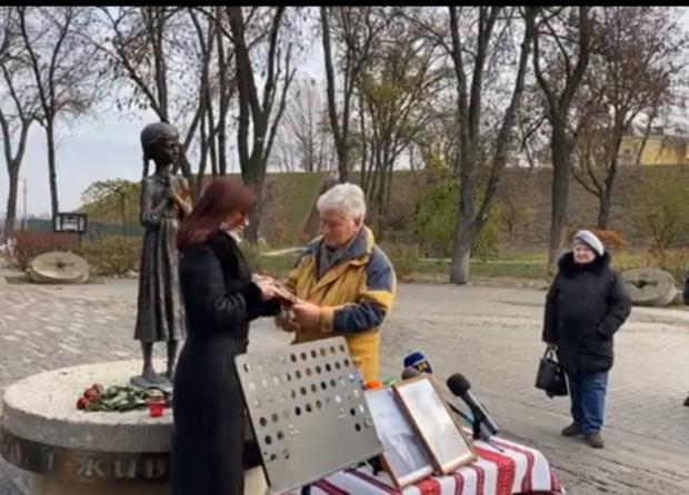 Марія Кириленко передала зошит Олександру Нечипоренку, а він - Олесі Стасюк, генеральній директорці Національного музею Голодомору-геноциду.