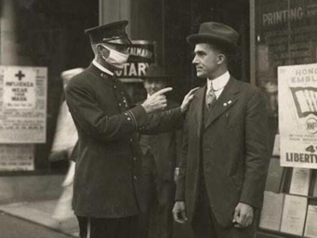 Поліцейський у Сан-Франциско попереджає чоловіка про можливе покарання за вихід на вулицю без маски в дні пандемії грипу (1918 рік)